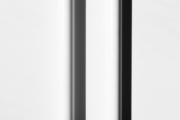Two white tubes with shadows, arranged in regular, parallel lines. Modern background. White, grey and black. Copy space.