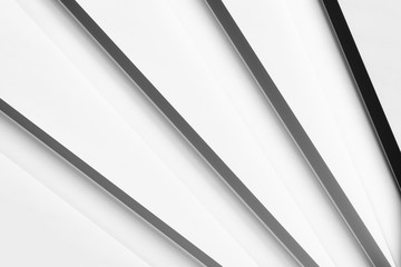 White tubes with shadows, arranged in geometric, regular lines. Modern background. White, grey and black.
