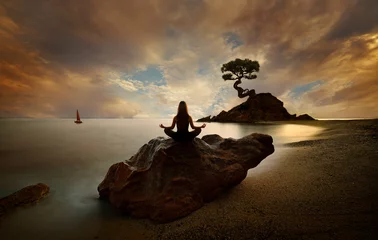 Rolgordijnen Vrouw doet yoga op het strand bij zonsopgang © quickshooting