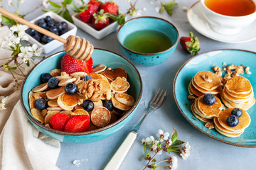 Trendy food during coronavirus Covid-19 lockdown quarantine - tiny pancakes. Poffertjes, Little Dutch pancakes. Breakfast for kids, mini pancakes.