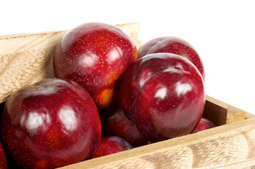 red apples in wooden box. White background. close view