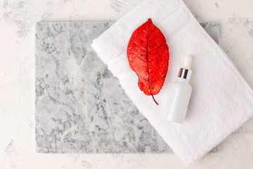 Organic vegan natural autumn season cosmetics concept. Cosmetic bottles of cream and serum essential on white marble background. Zero waste cosmetic package, sustainable wellness, dropper