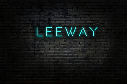 Neon sign with inscription leeway against brick wall