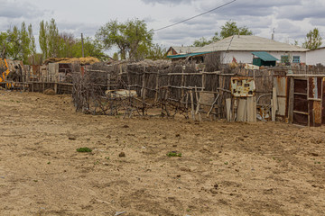 Fototapeta na wymiar Fence and a house in former port town Moynaq (Mo‘ynoq or Muynak), Uzbekistan