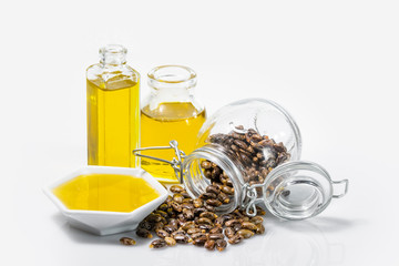 castor oil and grains in bowl isolated on white background