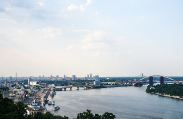 Fototapeta premium Panoramic view from new Pedestrian-Bicycle Bridge. Beautiful Dnipro River with bridges and residential houses at the background in the capital of Ukraine, Kyiv