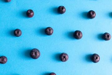 Fresh ripe blueberry berries pattern on a blue background.