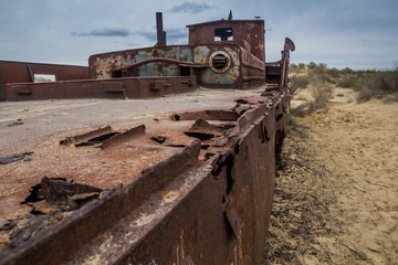 Fototapeta na wymiar Detail of a rusty ship at the ship graveyard in former Aral sea port town Moynaq (Mo‘ynoq or Muynak), Uzbekistan