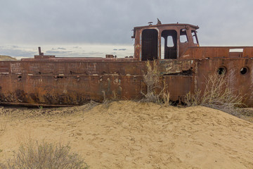 Fototapeta na wymiar Rusty ship at the ship graveyard in former Aral sea port town Moynaq (Mo‘ynoq or Muynak), Uzbekistan