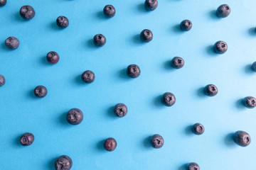 Fresh ripe blueberry berries pattern on a blue background.