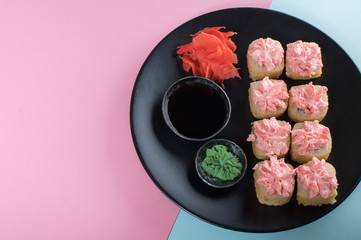Top view on the plate of rolls with pink cream