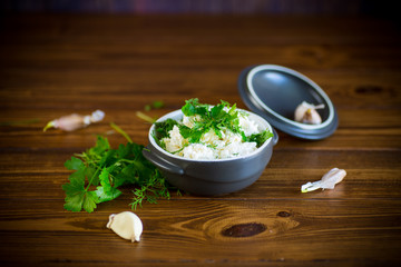 salted homemade cottage cheese with garlic and herbs in a bowl