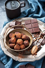 Composition with chocolate, coffee beans, truffles on dark table