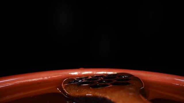 Pull Out over Honey Covered Dipper in Bowl on dark background