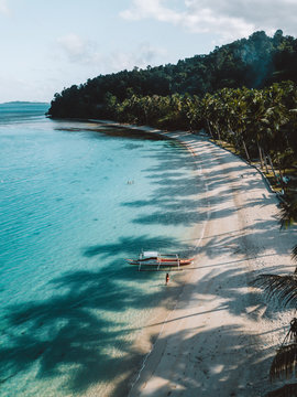 Aerial view of white beach in port barton, palawan, philippines with boat