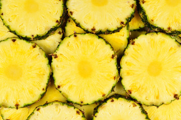 Pineapple juicy yellow slices background. Top view.