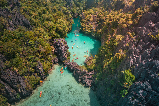 An aerial view of tourists kayaking going in and out in the Small Lagoon to Big Lagoon in Maniloc Island, El Nido, Palawan, Philippines.