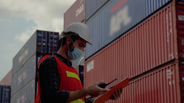 In the epidemic situation covid-19,Engineers must wear a mask while using the radio to communicate in the warehouse. Transportation industry
