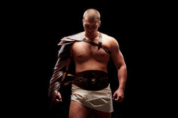 Fototapeta premium Gladiator with sword and armor on a black background