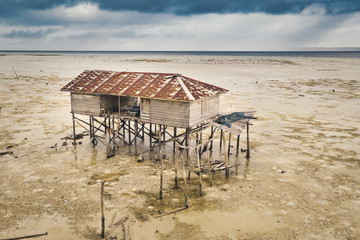 Aerial view of the fishing house at coast of Celebes Sea, Maratua, Indonesia. The house seems to be far from the sea due to low tide.