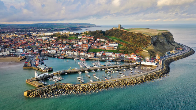 Aerial view of Scarborough harbour with lighthouse and castle, UK