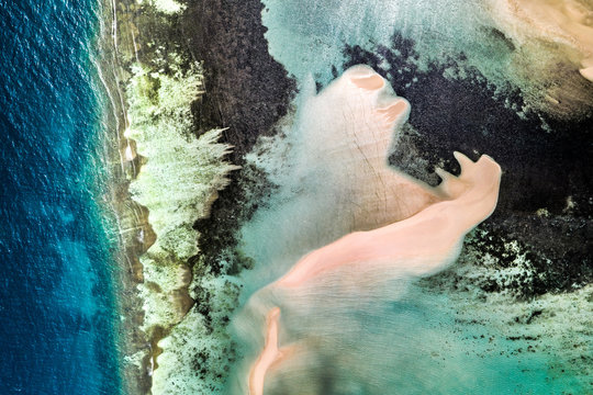 Aerial view of the shore of uninhabited island Maratua, near Borneo, Indonesia. Different colours result from various water depth as well as from different substrates, as the sand, coral reefs etc.