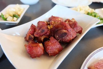 Close up fried fermented pork ribs, deep fried sour pork ribs on a white plate. Thai food.