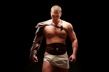 Fototapeta premium Gladiator with sword and armor on a black background