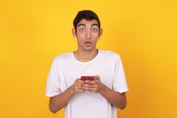 surprised young man with mobile phone isolated on background