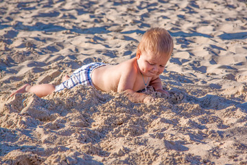 Relaxing on the beach. A child is sunbathing on the sand of the beach. Hot summer day by the sea.