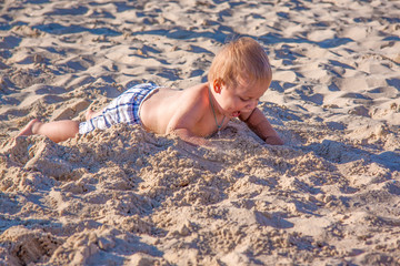 Relaxing on the beach. A child is sunbathing on the sand of the beach. Hot summer day by the sea.