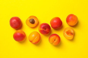 Fresh tasty apricots on yellow background, top view