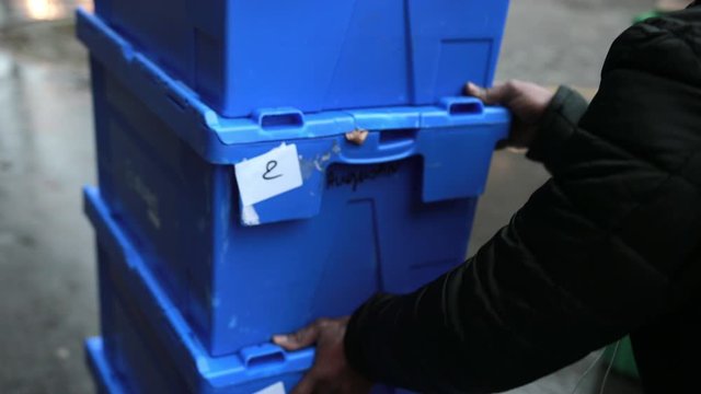 Close Up. The Hands Of An African-American Male Push Blue Boxes With Goods. Food Delivery, Street Courier