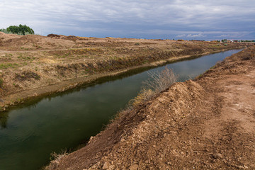Fototapeta na wymiar Water canal in Kyzylkum desert, Uzbekistan
