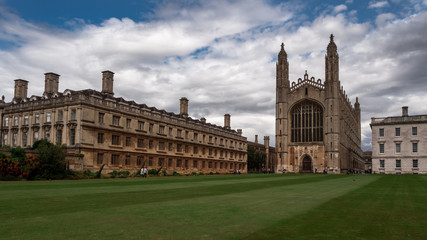 The historic buildings of the University of Cambridge. Green lawn and beautiful sky.