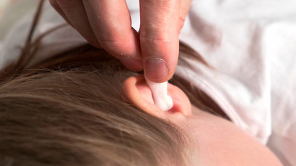 Put in sick ear by white cotton swab.