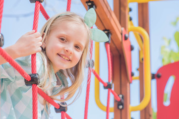 cute beautiful smiling little girl on a playground. Summer time fun