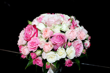 bouquet of pink and white roses for the bride stands on a black background