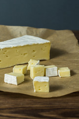 brie cheese. tasting cheese. diced cheese on wrapping paper