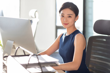 Young businesswoman using computer in office