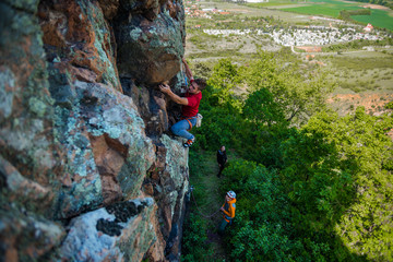 Sportive man exercising on wall for climbing