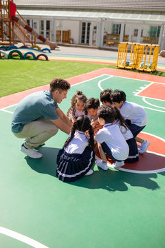 Foreign teacher and children playing in playground