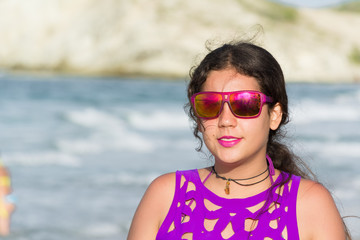 La joven está sonriendo y disfrutando la playa tranquila.
