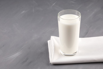Turkish fermented drink Ayran or Kefir in a glass on a grey background. Selective focus. Copy space