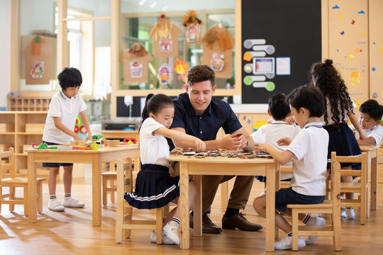 Foreign teacher and children playing in classroom