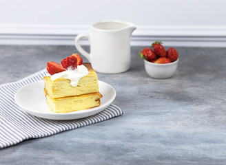 cottage cheese casserole with cream and strawberries on a white plate