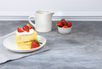 cottage cheese casserole with cream and strawberries on a white plate