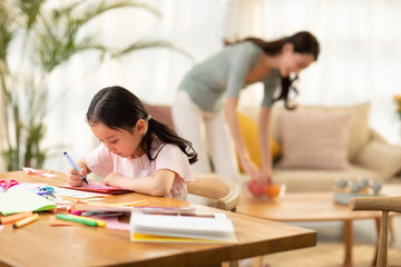 Little girl making greeting card for mother