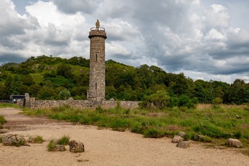 Famous Glenfinnan Monument from beginning of the 19th century with a statue of anonymous highlander in Scotland