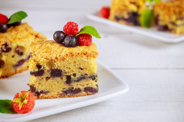 Berry sour cream cake on wooden background.